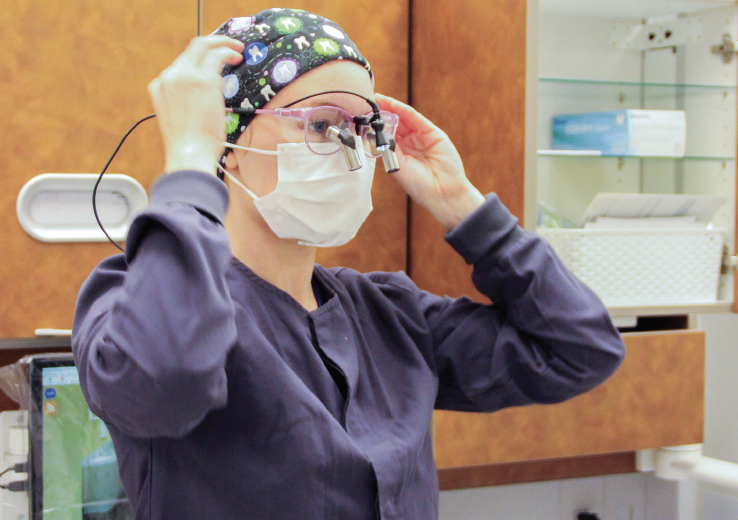 NE dental hygiene student Robin Zarate prepares her loupes. Loupes are strong
magnifying lenses attached to a frame to allow visibility of small details.